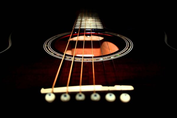 Three strings on a black guitar