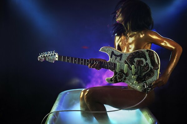 Ragazza con la chitarra in un bicchiere enorme