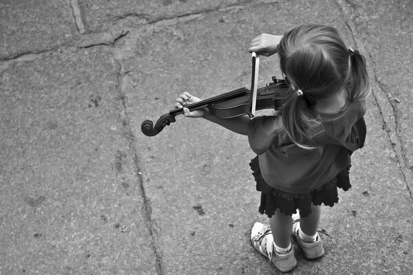 A girl plays the violin. Top view