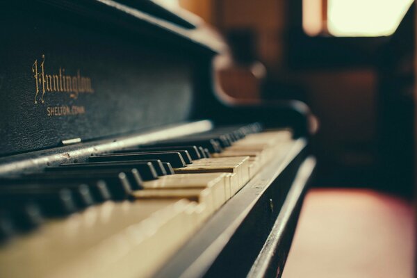 Un vecchio pianoforte si trova accanto a una finestra