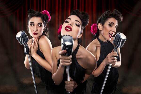 Tres chicas cantando en los micrófonos