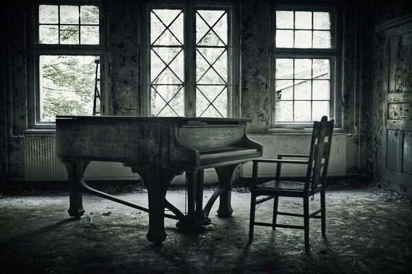 An abandoned room with a piano and a chair