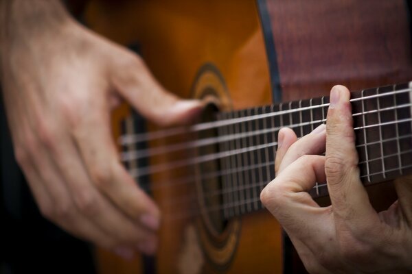 Mains jouant de la guitare