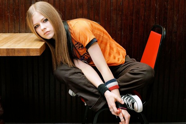 Avril Lavigne im orangefarbenen T-Shirt