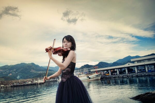 Violoniste en robe de soirée sur la baie