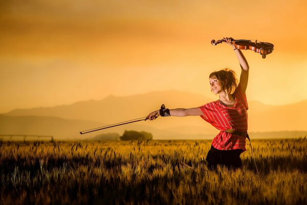 Lindsay Stirling at sunset with a violin