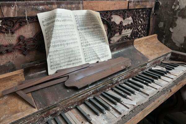 Vecchio pianoforte polveroso con il libro di musica