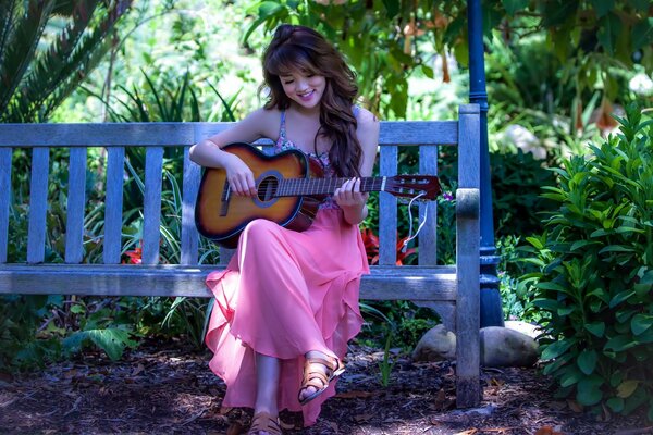 Morena se sienta en un banco y toca la guitarra