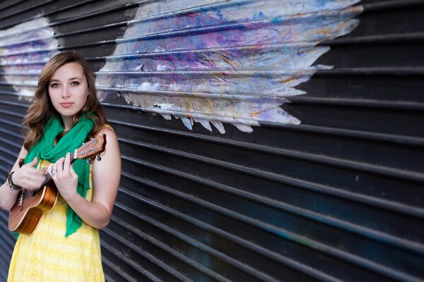 Fille avec des ailes joue de la guitare