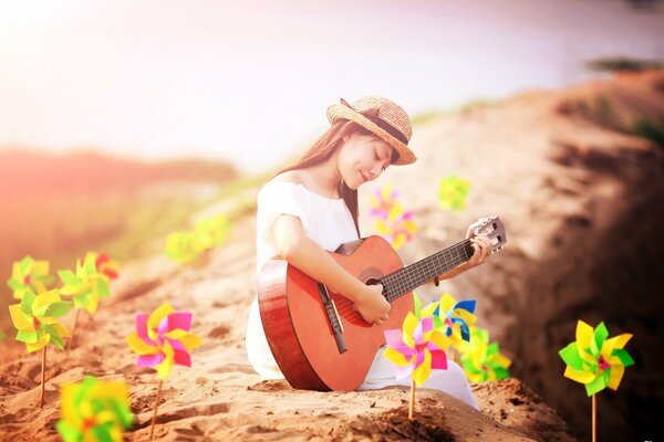 Mädchen mit Gitarre am Meer