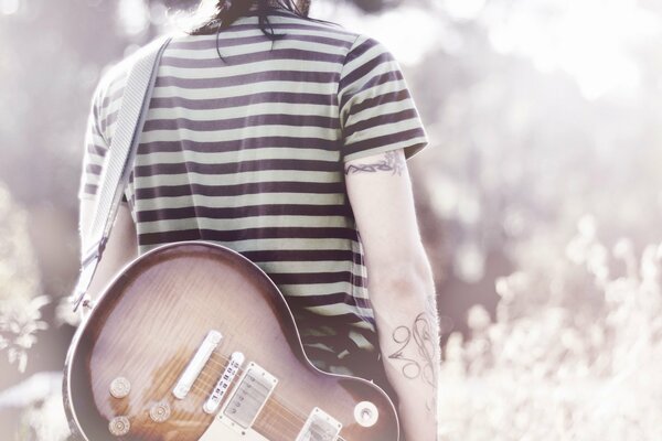 Musiker mit Gitarre mit Tattoos an den Händen