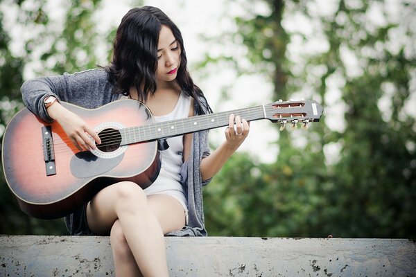 Beautiful girl playing music on guitar