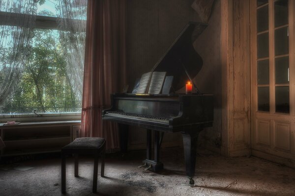 Foto de un piano con una vela en él