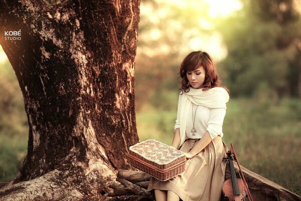 Joven violinista con Caja de picnic de mimbre