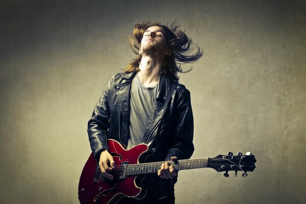 Guy blond avec une guitare rouge