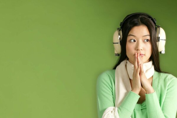 Japanese girl wearing headphones on a green background