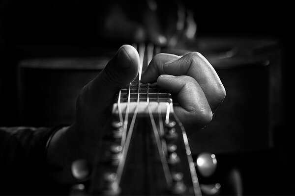 Fingers squeeze guitar strings