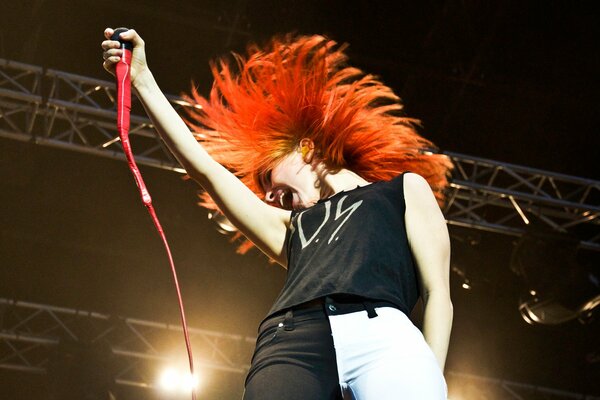 A red-haired singer sings on stage