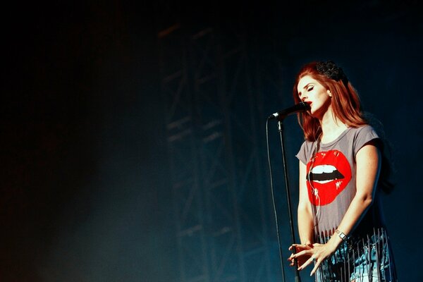 Cantante pelirroja con una camiseta brillante en el escenario