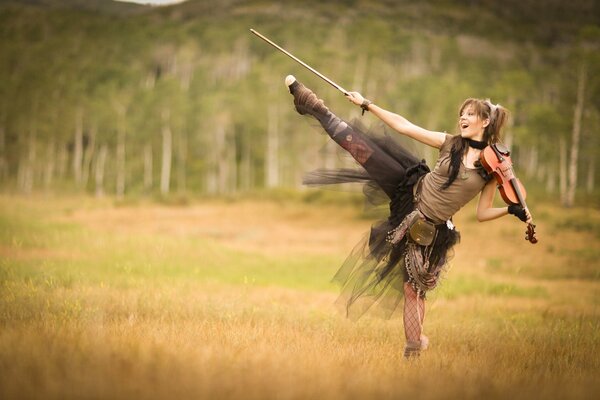 Dancing girl in the field with a violin