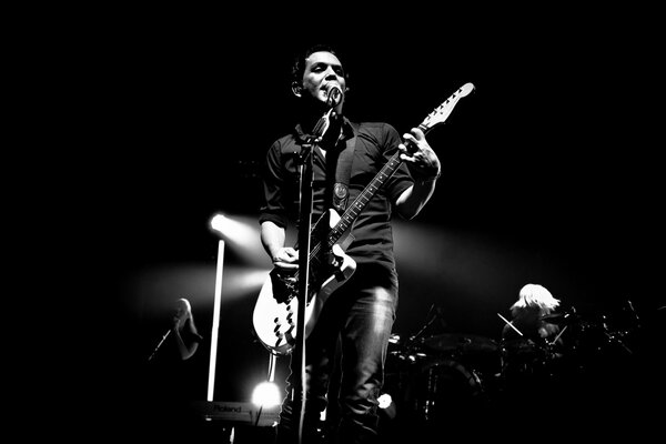 Dark silhouette of a man with a guitar on stage