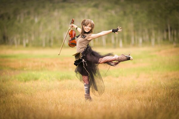 Ragazza in campo con violino in movimento