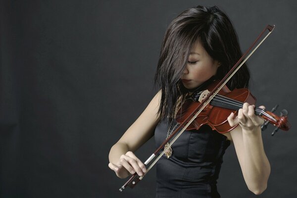 Chica tocando una melodía en el violín