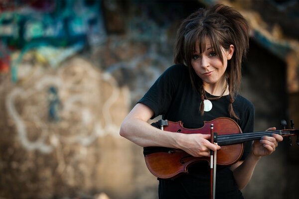 Mignon violoniste sur fond de mur