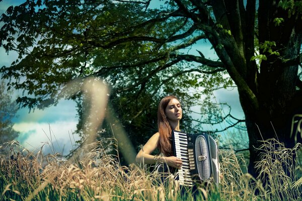 Ragazza con fisarmonica sullo sfondo della natura