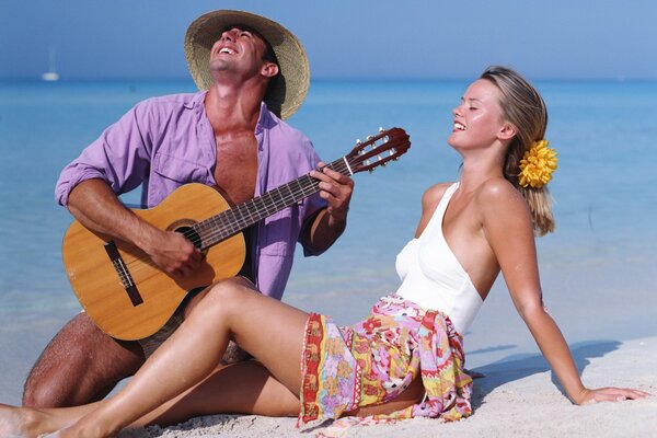 A guy plays guitar for his beloved by the sea