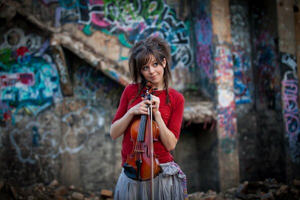 Lindsay Stirling and a violin near a painted wall