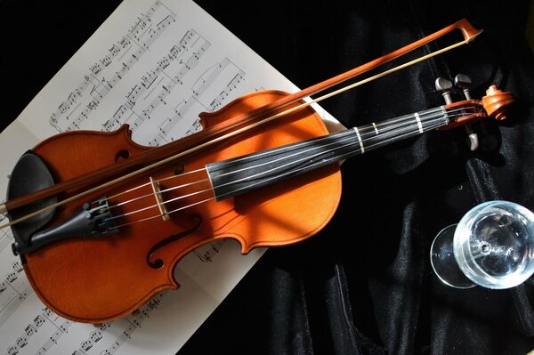 A bow with a violin on a notebook with notes