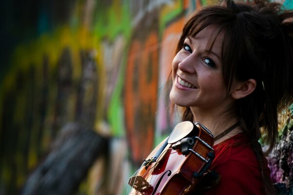 Chica sonriente en el fondo de graffiti con violín