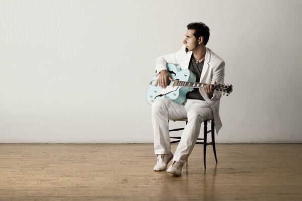 A musician sitting on a chair in an empty room