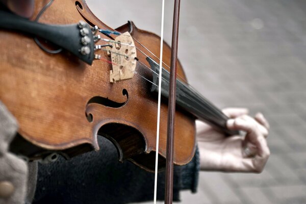 A man is playing a violin on the street