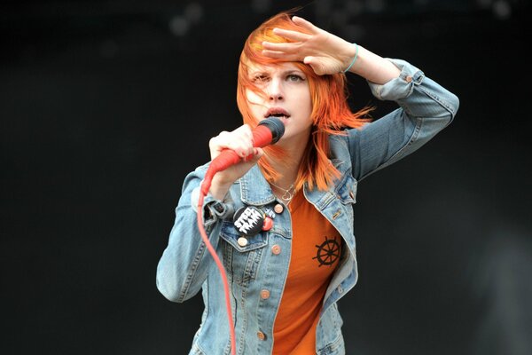 Singer Hayley Williams sings with a pink microphone