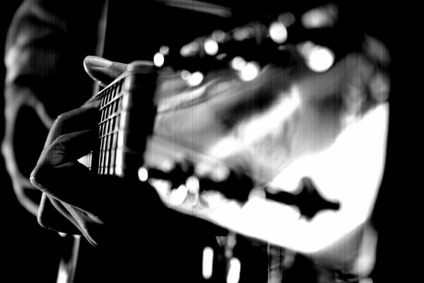 Photo of a guitar with fingers on strings