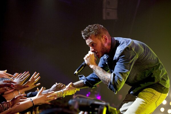 The audience stretches their hands at the singer s concert