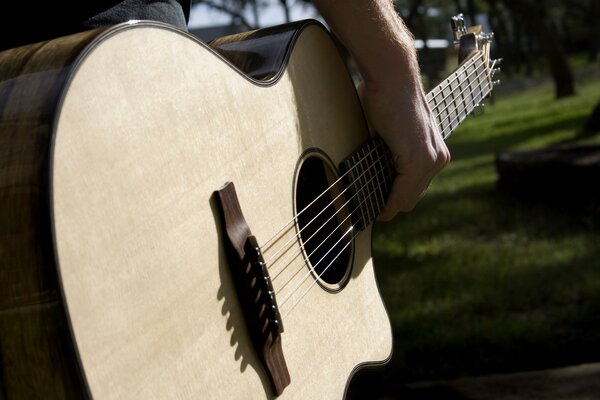 Close-up of guitar in the guitarist s hand gref and soundboard strings