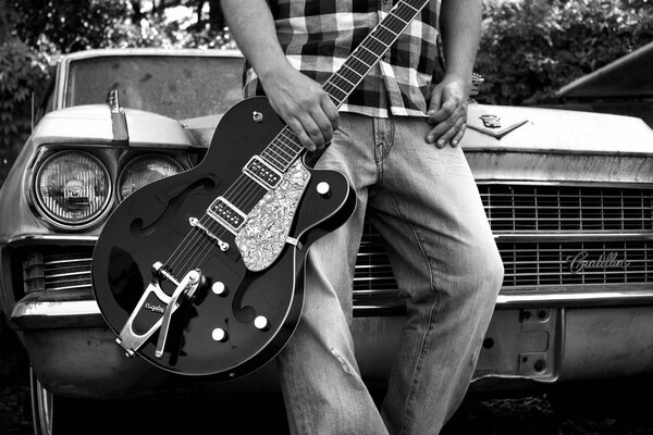 Auto retrò. Ragazzo con la chitarra sullo sfondo della macchina