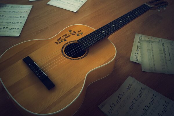 Gitarre auf dem Tisch unter den Noten