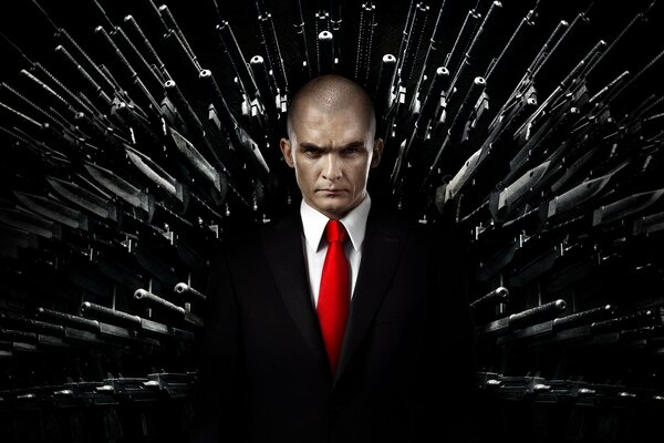 Hitman:Agent 47, Rupert Freund im schwarzen Anzug und roter Krawatte