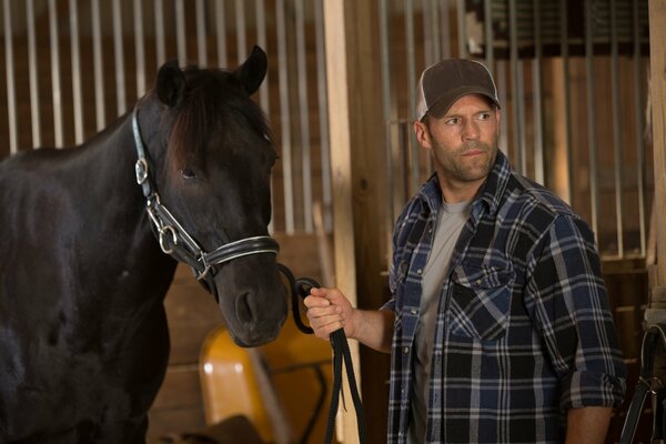 Jason Stetham avec un cheval à l écurie