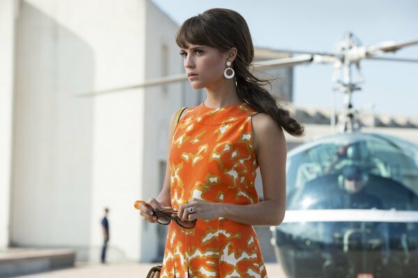 Alicia Vikander w pobliżu helikoptera