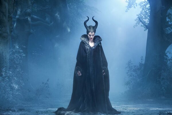 Maleficent in the night forest in the fog