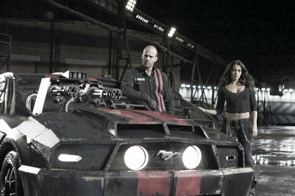 A man and a woman standing next to a car