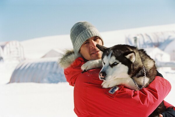 Actor Paul Walker and a husky dog breed among the snows