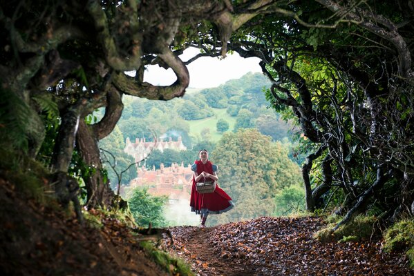 A girl with a basket is heading into the forest