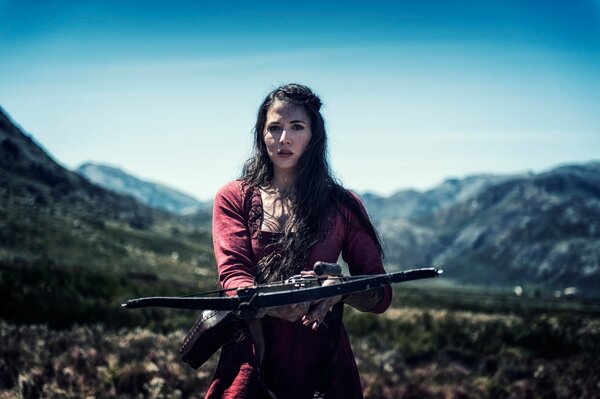 Fille avec un arc, autour de la montagne et le jour clair