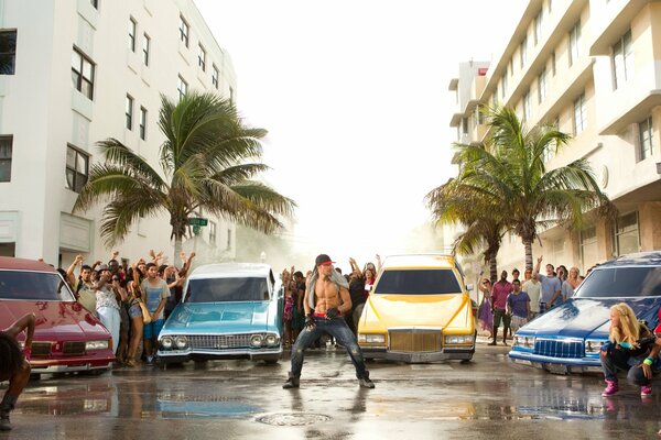 Dance battle against the background of cool cars